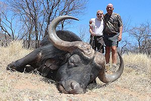 A proud pair of hunters alongside a buffalo trophy.