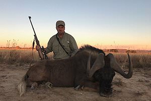 A hunter with a black wildebeest trophy.
