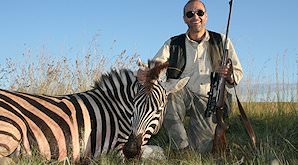 A hunter smiles alongside his Burchell's zebra trophy.