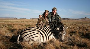 A huntress smiles with her zebra trophy.