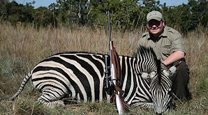 A hunter poses with his zebra.