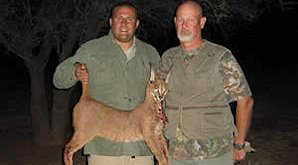 A hunter presents his caracal trophy for a photograph.