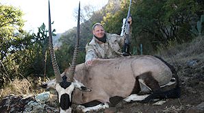 A gemsbok trophy is presented for a commemorative photograph.
