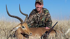 An hunter presents his impala trophy for a photo.