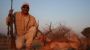 A hunter holds up his impala for a photo.