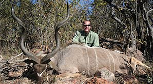 A hunter sits behind his striking kudu trophy.