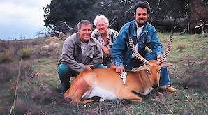 A team of hunters present a lechwe trophy for a photo.