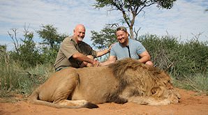 A hunter with his lion trophy and his professional hunter.
