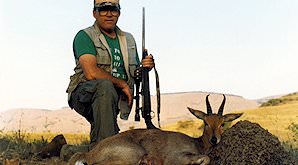 A hunter kneels next to his mountain reedbuck trophy.