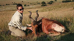 A young hunter props up his red hartebeest trophy for a photograph.