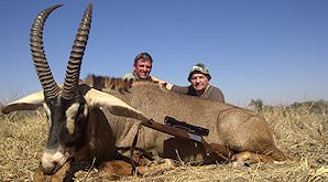 A hunter with his PH and roan antelope trophy.