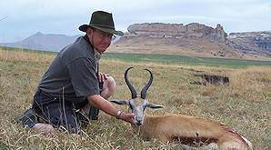 A hunter holds up his springbok trophy.