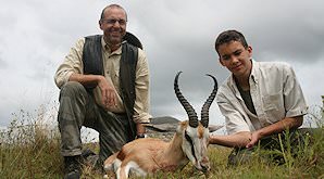 A hunter, his son and their springbok trophy.