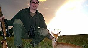 A hunter sits behind his steenbok trophy.