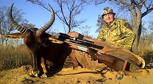 A hunter poses with his tsessebe for a photograph.