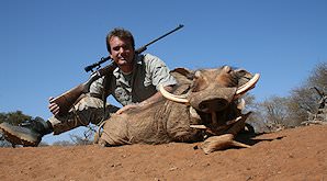 A proud hunter with his warthog trophy.