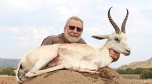 A hunter presents a white springbok trophy for a photo.
