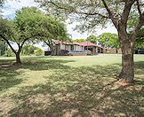 Lush lawns and thorn trees surround this bushveld hunting camp.
