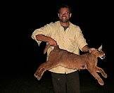 A hunter holds up his caracal trophy.