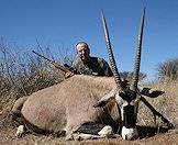 A hunter presents his gemsbok trophy for a photograph.