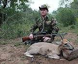 A hunter positions his grey duiker trophy for a memorable photograph.