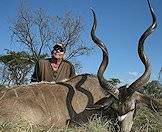 A hunter smiles triumphantly alongside his kudu trophy.