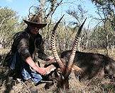 A hunter presents his waterbuck trophy for a photograph.