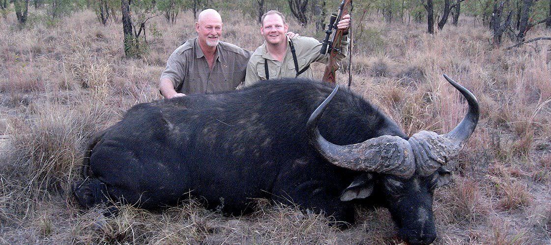 A pair of proud hunters with their Cape buffalo trophy.
