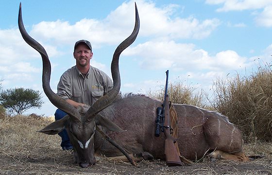 A hunter and his PH present a kudu trophy for a photograph.