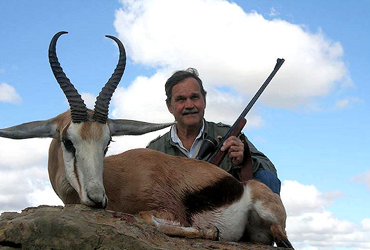 A hunter sits proudly alongside his springbok trophy in the Free State.