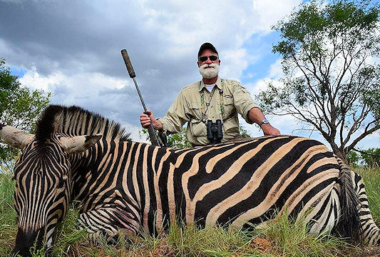 A hunter poses with his zebra.