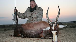 A hunter poses behind his blesbok trophy.