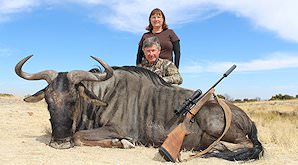 A hunter, his partner and their blue wildebeest trophy.