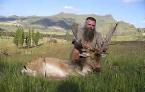 A hunter presents his fallow deer for photograph.