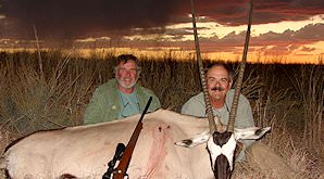 A gemsbok trophy is presented for a commemorative photograph.