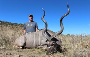 A proud hunter sits alongside his kudu trophy.