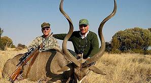 A pair of hunters pose with a kudu trophy for a photograph.