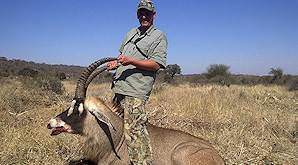 A hunter holds his roan antelope trophy by the horns.