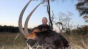 A young hunter smiles with his ostrich trophy.