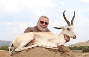 A hunter presents his white springbok trophy for a photograph.