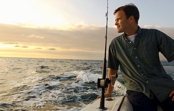 A fisherman enjoys the sunset.