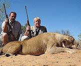 Hunters pose with a lioness.