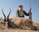 A hunter poses for a shot with a blesbok.