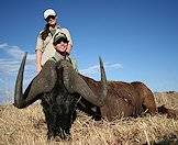 Hunters pose proudly next to their black wildebeest trophy.