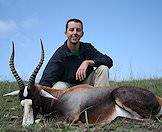 A hunter poses alongside a blesbok trophy.