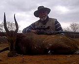 A hunter poses for a photograph with his bushbuck trophy.