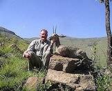 A hunter presents his grey rhebok trophy for a photograph.