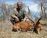 A hunter sits for a photograph with his impala trophy.