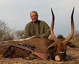 A hunter, his rifle and his nyala trophy.