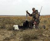 A hunter proudly presents his ostrich trophy for a photograph.